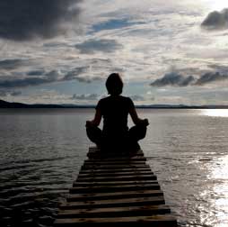 Woman meditating on dock photo